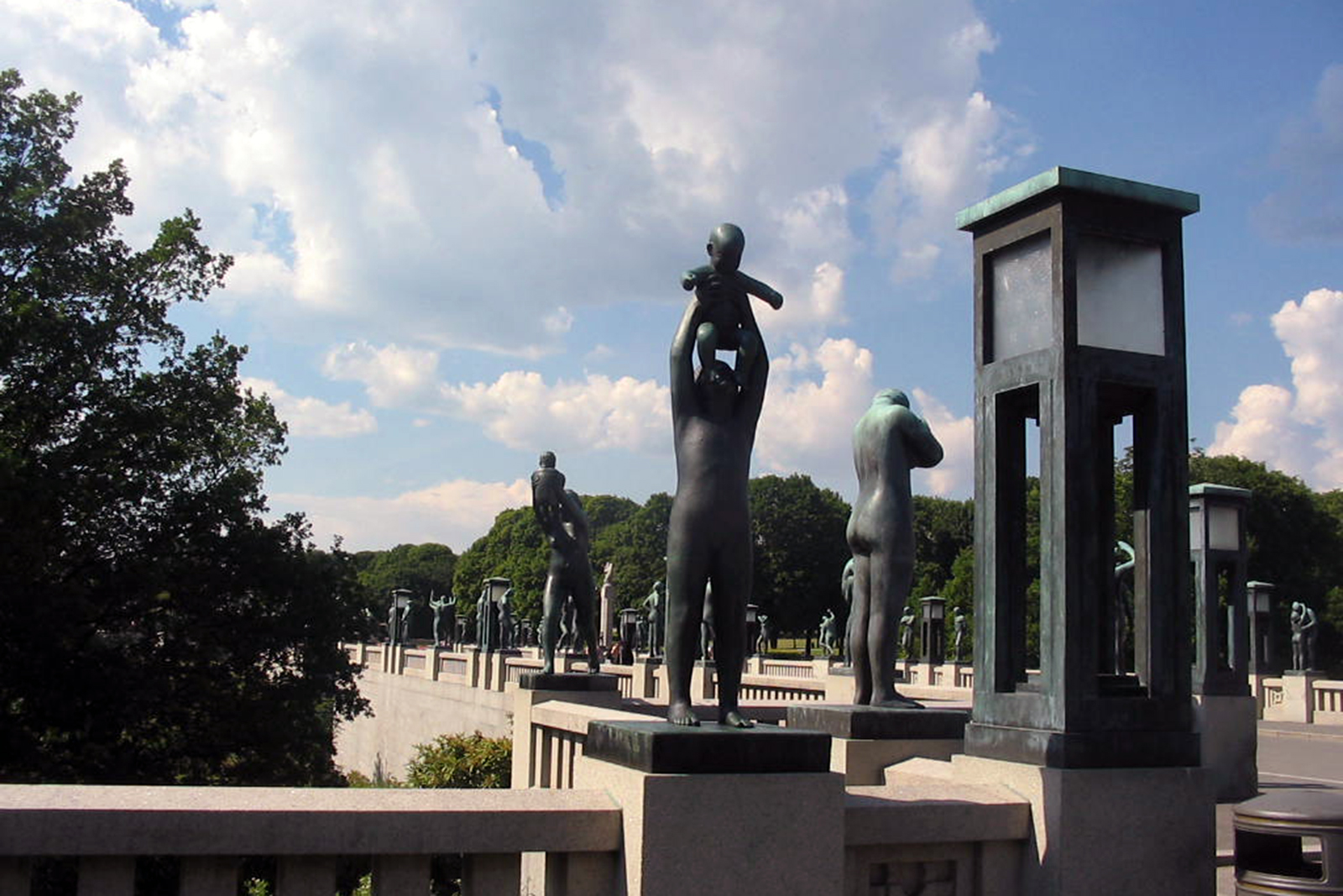 Photo of a park in Oslo, Norway with various statues and trees and the sky in the background.